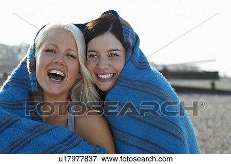 Two women laughing covered under blanket portrait View Large Photo Image Stock Photo - Two women laughing covered under blanket portrait. Fotosearch