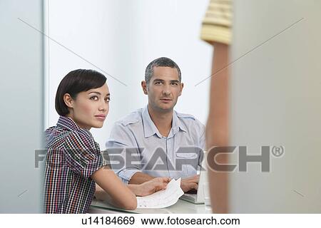 Two workers looking up at co-worker (mid section) standing in office doorway View Large Photo Image Stock Photo - Two workers looking up at co-worker (mid section) standing in office doorway. Fotosearch