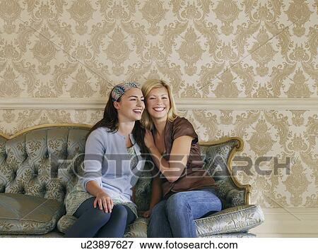 Two young women sitting on sofa portrait View Large Photo Image Stock Photo - Two young women sitting on sofa portrait. Fotosearch