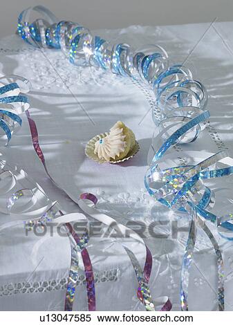 Unfinished cup cake amongst streamers on table elevated view View Large Photo Image Stock Photography - Unfinished cup cake amongst streamers on table elevated view. Fotosearch