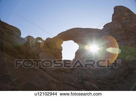 USA sun shining through rock formation in desert View Large Photo Image Picture - USA sun shining through rock formation in desert. Fotosearch
