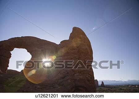 USA sun shining through rock formation in desert View Large Photo Image Stock Image - USA sun shining through rock formation in desert. Fotosearch