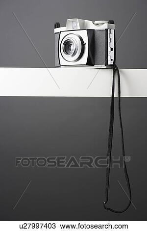 Stock Image - Vintage photo camera on shelf studio shot. Fotosearch