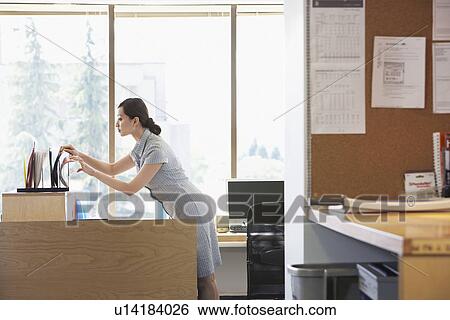 Woman checking files in office View Large Photo Image Stock Photograph - Woman checking files in office. Fotosearch