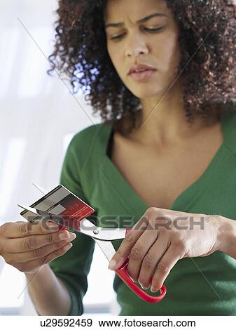 Stock Photo - Woman cutting credit card low angle view. Fotosearch