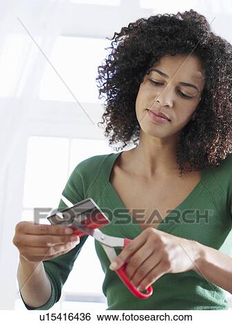 Woman cutting credit card low angle view View Large Photo Image Stock Photograph - Woman cutting credit card low angle view. Fotosearch