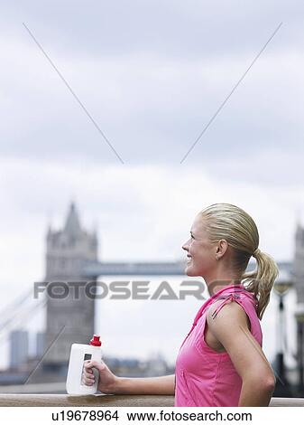 Woman drinking water in front of Tower Bridge England London View Large Photo Image Picture - Woman drinking water in front of Tower Bridge England London. Fotosearch