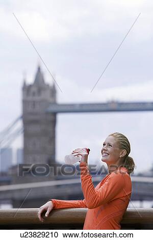 Woman drinking water in front of Tower Bridge England London View Large Photo Image Stock Image - Woman drinking water in front of Tower Bridge England London. Fotosearch