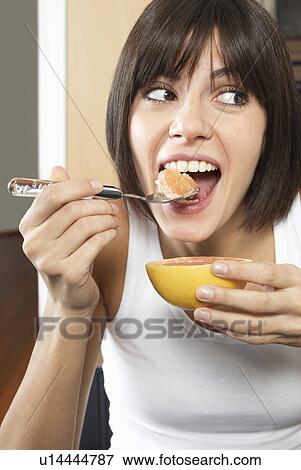 Woman eating grapefruit View Large Photo Image Stock Photo - Woman eating grapefruit. Fotosearch