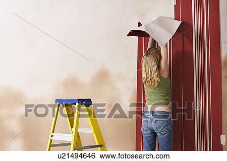 Woman hanging wallpaper back view View Large Photo Image Stock Photograph - Woman hanging wallpaper back view. Fotosearch