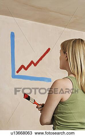 Woman holding paintibrush facing wall with painted diagram View Large Photo Image Stock Image - Woman holding paintibrush facing wall with painted diagram. Fotosearch