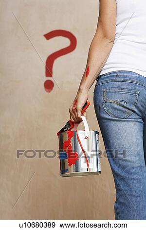 Woman holding painting can facing wall with painted question mark mid section back view View Large Photo Image Stock Photo - Woman holding painting can facing wall with painted question mark mid section back view. Fotosearch