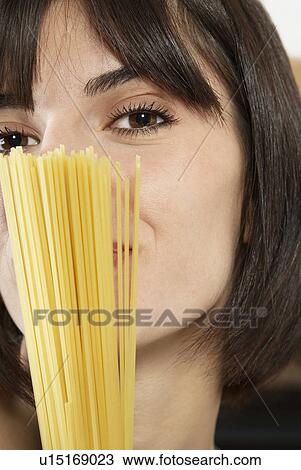 Woman holding uncooked spaghetti portrait close up View Large Photo Image Stock Image - Woman holding uncooked spaghetti portrait close up. Fotosearch