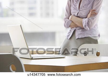 Woman in office focus on laptop in foreground View Large Photo Image Stock Photography - Woman in office focus on laptop in foreground. Fotosearch