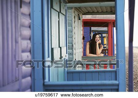 Stock Photo - Woman leaning on balustrade of beach house. Fotosearch