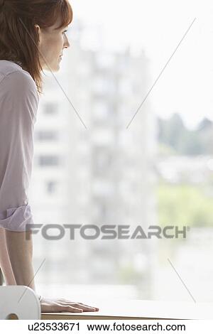 Woman looking out of window View Large Photo Image Stock Image - Woman looking out of window. Fotosearch