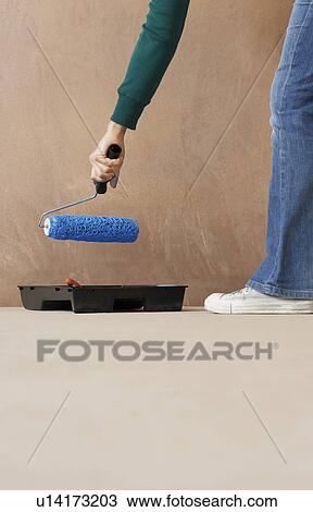 Woman painting wall with paint roller low section View Large Photo Image Stock Image - Woman painting wall with paint roller low section. Fotosearch