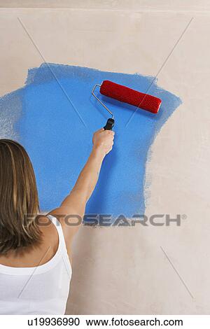 Woman painting wall with paint roller back view View Large Photo Image Stock Image - Woman painting wall with paint roller back view. Fotosearch