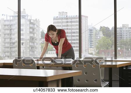 Woman reading at desk in office View Large Photo Image Stock Image - Woman reading at desk in office. Fotosearch