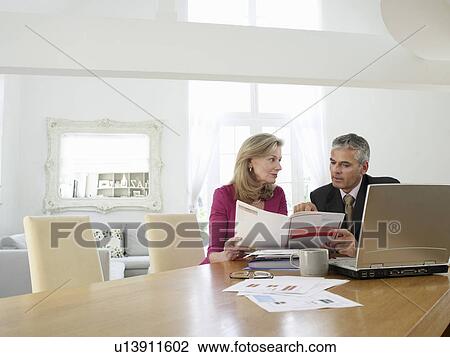Woman sitting at table with financial advisor View Large Photo Image Stock Image - Woman sitting at table with financial advisor. Fotosearch