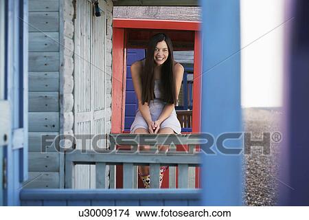 Woman sitting on balustrade of beach house portrait View Large Photo Image Picture - Woman sitting on balustrade of beach house portrait. Fotosearch