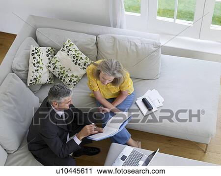Woman sitting on sofa with financial advisor elevated view View Large Photo Image Stock Image - Woman sitting on sofa with financial advisor elevated view. Fotosearch
