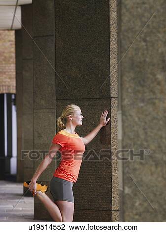 Woman stretching against a pillar View Large Photo Image Stock Image - Woman stretching against a pillar. Fotosearch