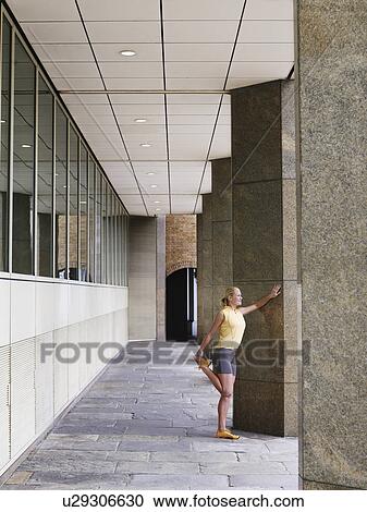 Woman stretching against a pillar View Large Photo Image Stock Image - Woman stretching against a pillar. Fotosearch