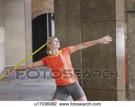 Woman throwing javelin outside building View Large Photo Image Stock Image - Woman throwing javelin outside building. Fotosearch