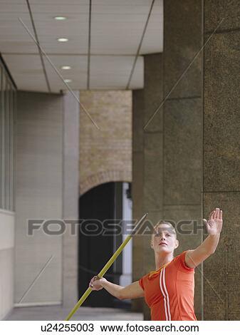 Woman throwing javelin outside building View Large Photo Image Stock Image - Woman throwing javelin outside building. Fotosearch