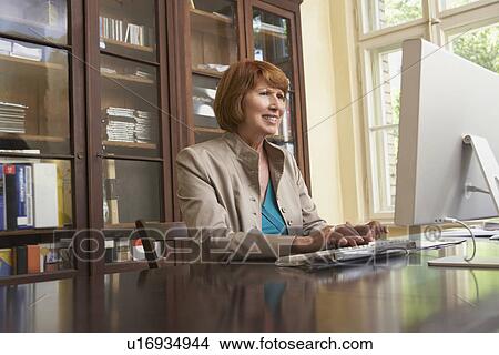 Woman using computer in living room View Large Photo Image Picture - Woman using computer in living room. Fotosearch