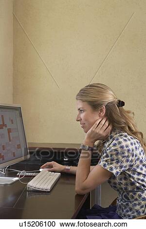 Stock Image - Woman using computer in office. Fotosearch