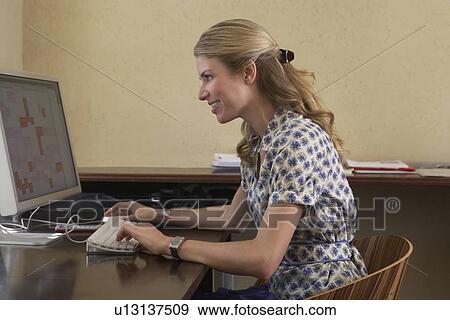 Stock Photo - Woman using computer in office. Fotosearch