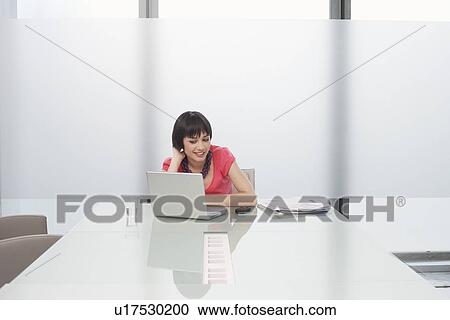 Woman using laptop in modern cubicle View Large Photo Image Stock Image - Woman using laptop in modern cubicle. Fotosearch