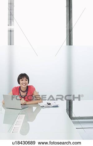 Woman using laptop in modern cubicle View Large Photo Image Stock Photo - Woman using laptop in modern cubicle. Fotosearch