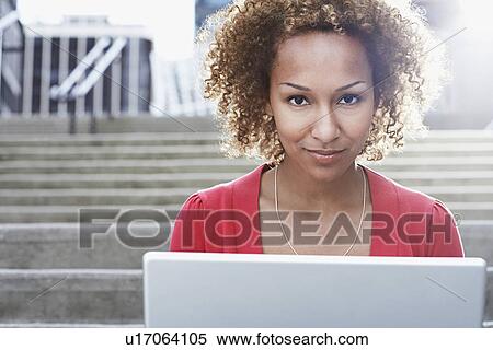 Woman using laptop on steps close-up portrait View Large Photo Image Stock Photography - Woman using laptop on steps close-up portrait. Fotosearch