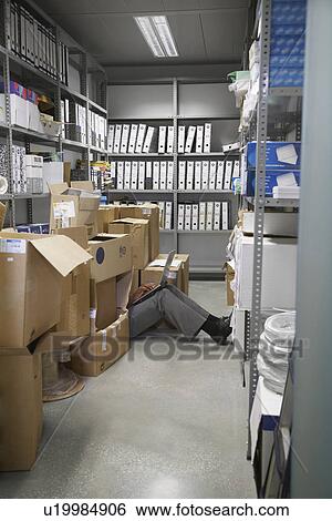 Woman using laptop sitting on floor between boxes in storage room View Large Photo Image Stock Photograph - Woman using laptop sitting on floor between boxes in storage room. Fotosearch