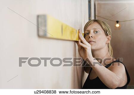 Woman using spirit level View Large Photo Image Stock Photo - Woman using spirit level. Fotosearch