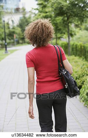 Woman walking through park View Large Photo Image Stock Image - Woman walking through park. Fotosearch