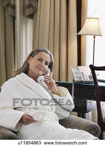 Woman wearing bathrobe using phone in living room portrait View Large Photo Image Stock Image - Woman wearing bathrobe using phone in living room portrait. Fotosearch