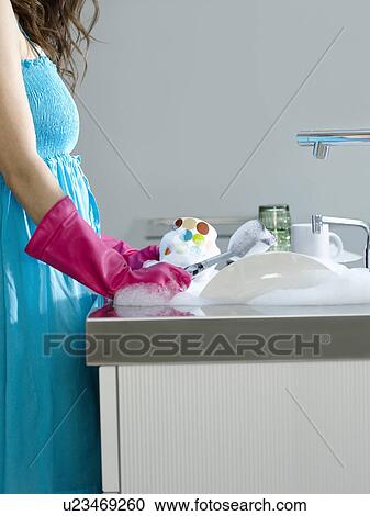 Woman wearing dress and rubber gloves washing dishes side view mid section View Large Photo Image Stock Image - Woman wearing dress and rubber gloves washing dishes side view mid section. Fotosearch