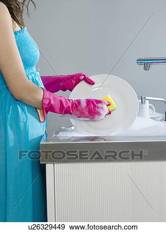 Woman wearing dress and rubber gloves washing dishes side view mid section View Large Photo Image Stock Photo - Woman wearing dress and rubber gloves washing dishes side view mid section. Fotosearch