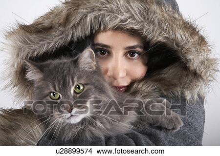 Woman wearing hooded coat holding cat portrait close-up View Large Photo Image Picture - Woman wearing hooded coat holding cat portrait close-up. Fotosearch