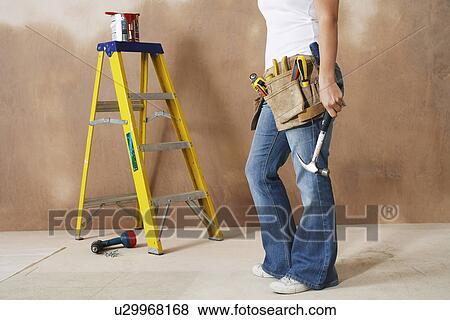 Stock Photo - Woman with toolbelt and hummer low section. Fotosearch