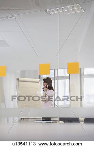 Woman working in office talking on phone View Large Photo Image Stock Image - Woman working in office talking on phone. Fotosearch
