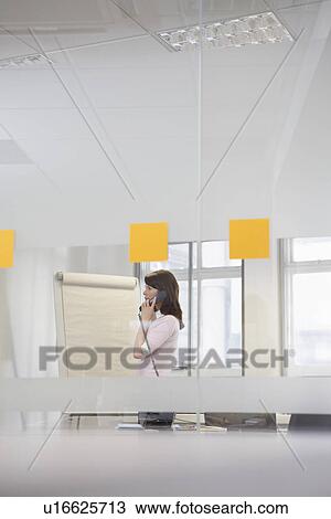 Woman working in office talking on phone View Large Photo Image Stock Image - Woman working in office talking on phone. Fotosearch