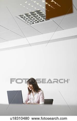 Woman working on laptop in office View Large Photo Image Stock Image - Woman working on laptop in office. Fotosearch