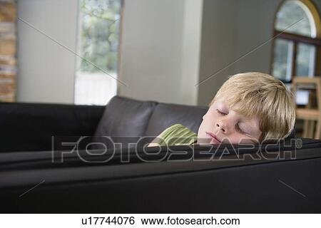 Young boy (5-6) sleeping on sofa View Large Photo Image Stock Photograph - Young boy (5-6) sleeping on sofa. Fotosearch