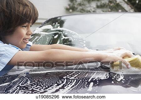 Young boy (7-9) washing car with sponge side view View Large Photo Image Stock Photograph - Young boy (7-9) washing car with sponge side view. Fotosearch