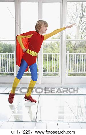 Young boy (7-9) wearing superhero costume arm extended side view View Large Photo Image Stock Photo - Young boy (7-9) wearing superhero costume arm extended side view. Fotosearch